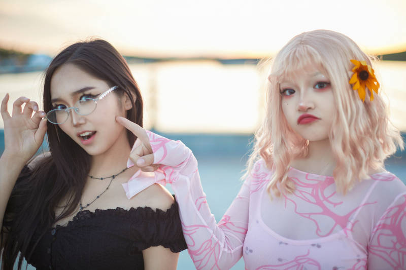 在旅游区湖边打卡点拍照的美女闺蜜