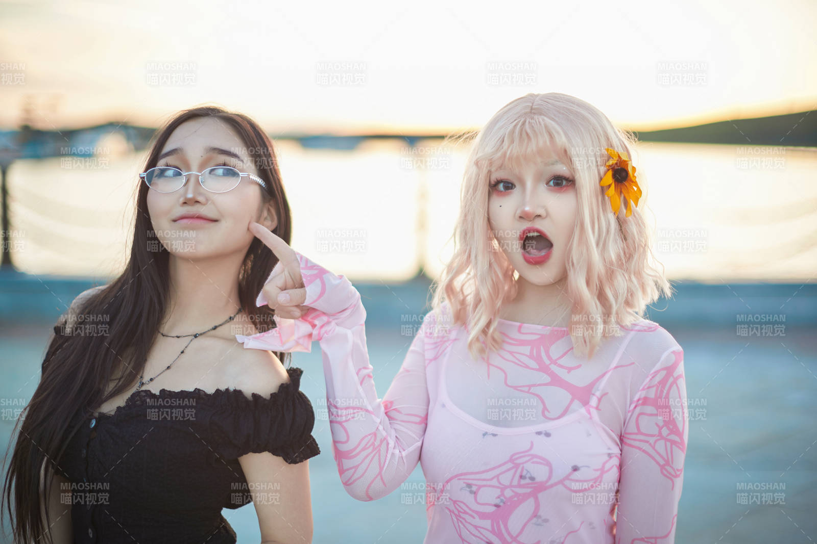在旅游区湖边打卡点拍照的美女闺蜜