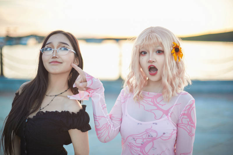 在旅游区湖边打卡点拍照的美女闺蜜