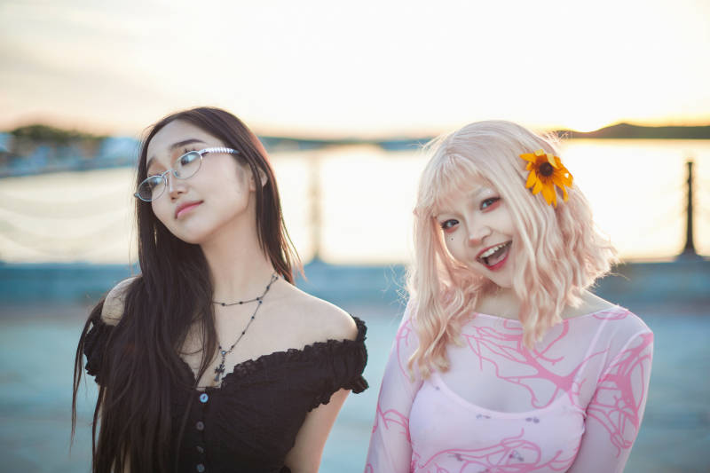 在旅游区湖边打卡点拍照的美女闺蜜