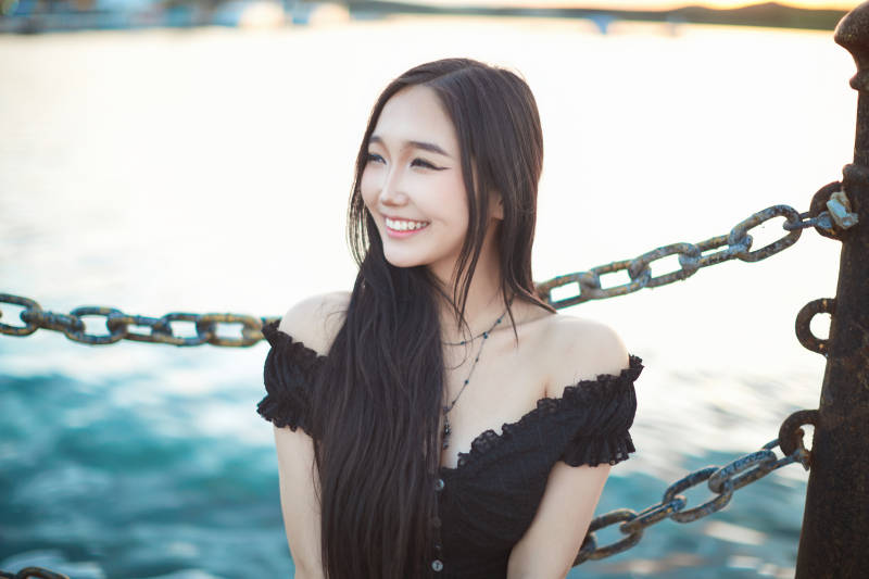 夕阳湖边打卡点拍照的美丽亚洲女性