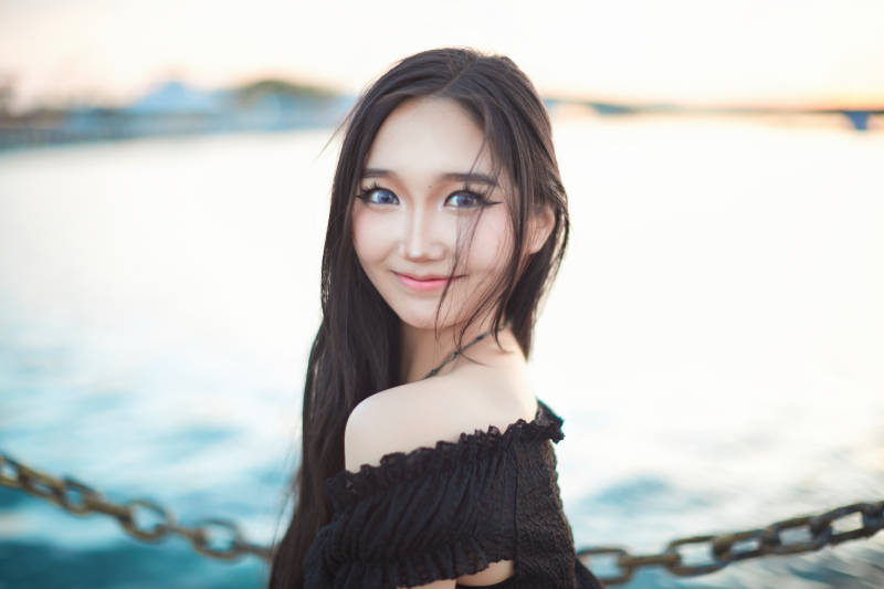 夕阳湖边打卡点拍照的美丽亚洲女性