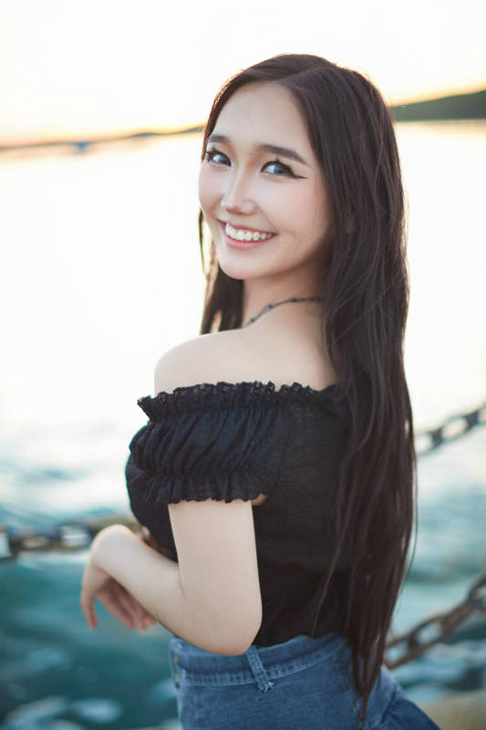 夕陽湖邊打卡點拍照的美麗亞洲女性