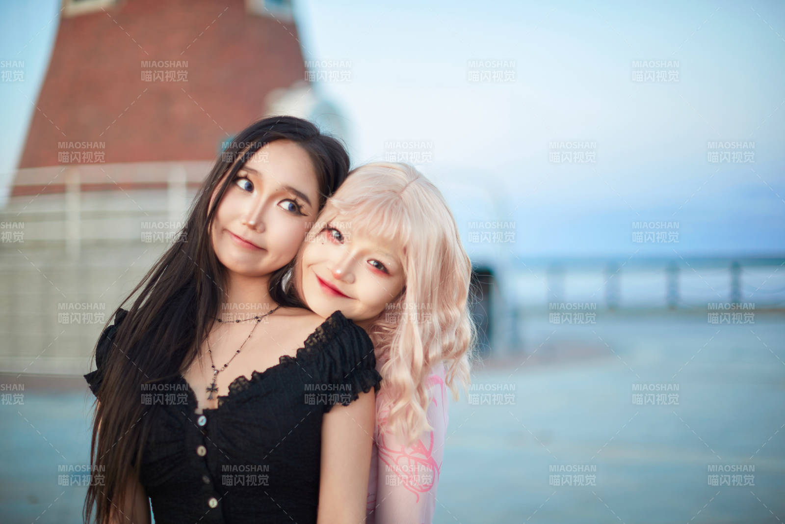 在旅游区湖边打卡点拍照的美女闺蜜