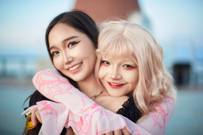 在旅游区湖边打卡点拍照的美女闺蜜