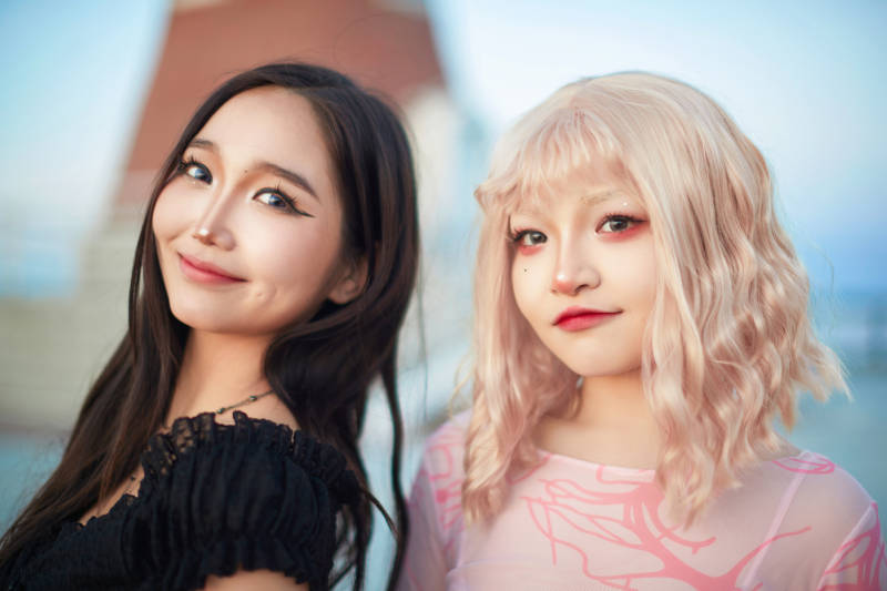 在旅游区湖边打卡点拍照的美女闺蜜