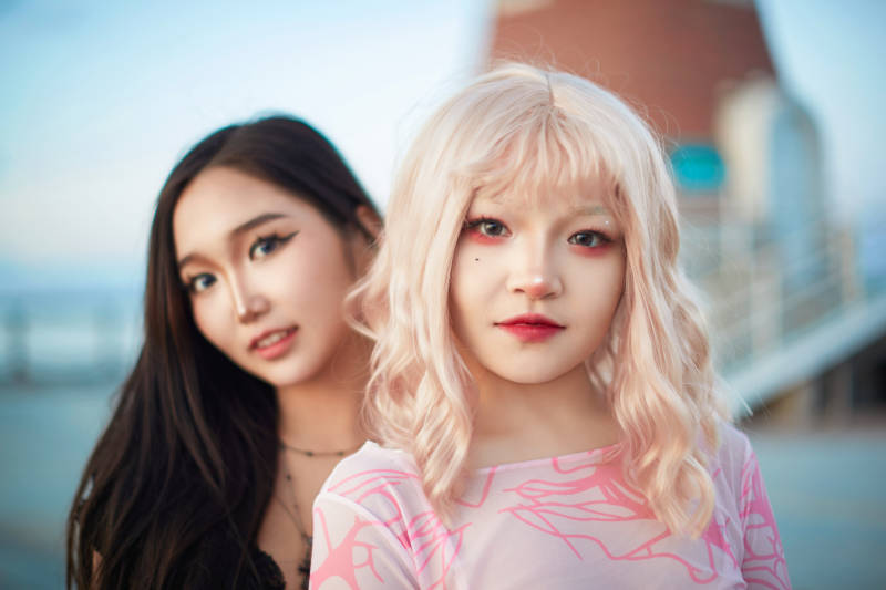 在旅游区湖边打卡点拍照的美女闺蜜