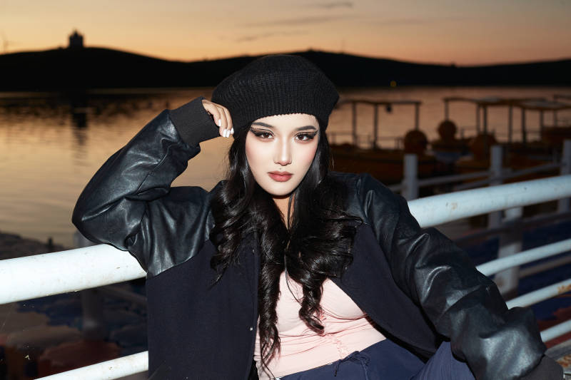 傍晚在湖边欣赏风景拍照的蒙古族美女