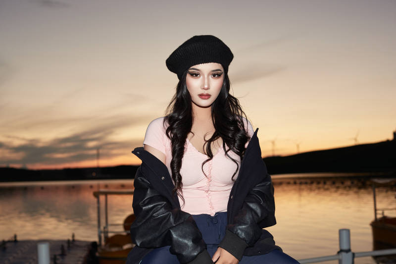 傍晚在湖边欣赏风景拍照的蒙古族美女