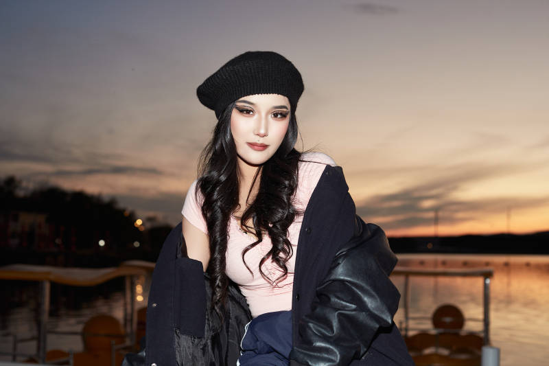 傍晚在湖边欣赏风景拍照的蒙古族美女