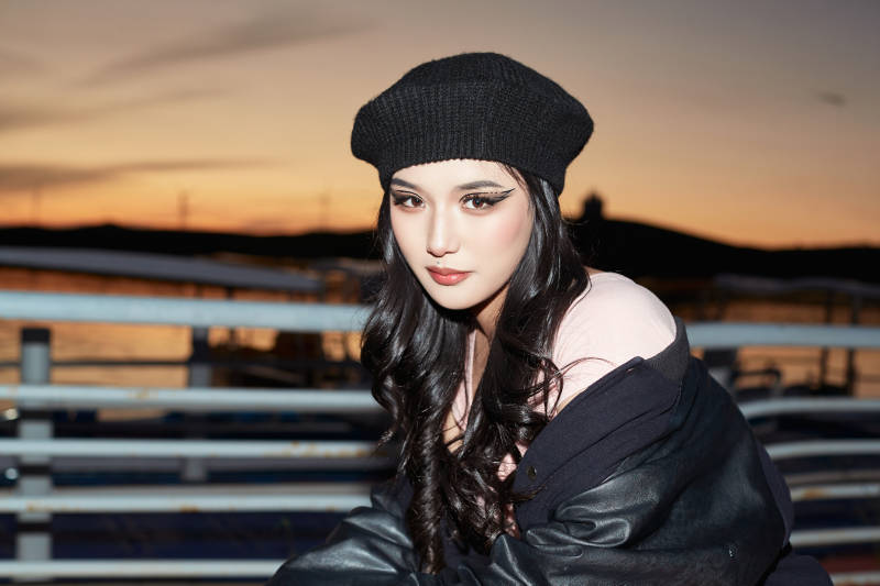 傍晚在湖边欣赏风景拍照的蒙古族美女