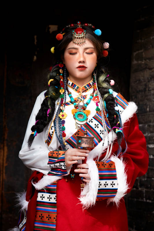 身穿藏族服饰在古城拍照的少女