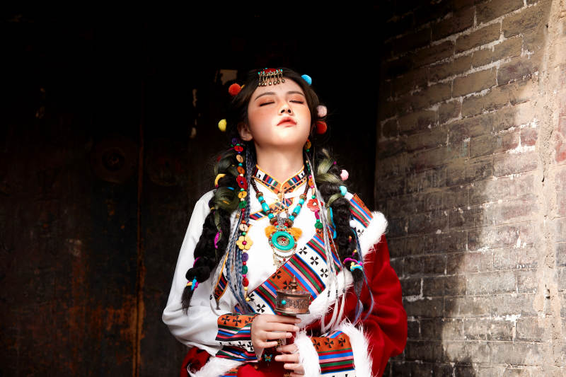 身穿藏族服饰在古城拍照的少女