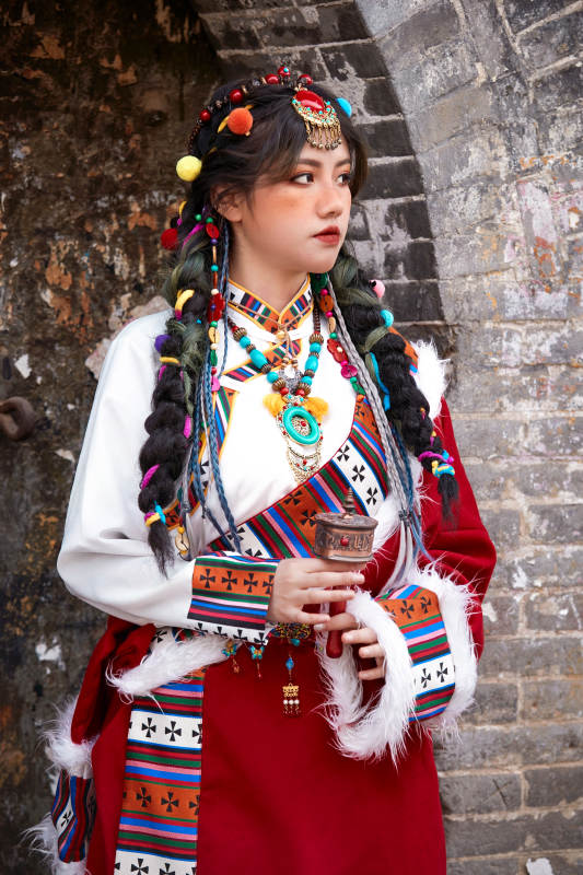 身穿藏族服饰在古城拍照的少女