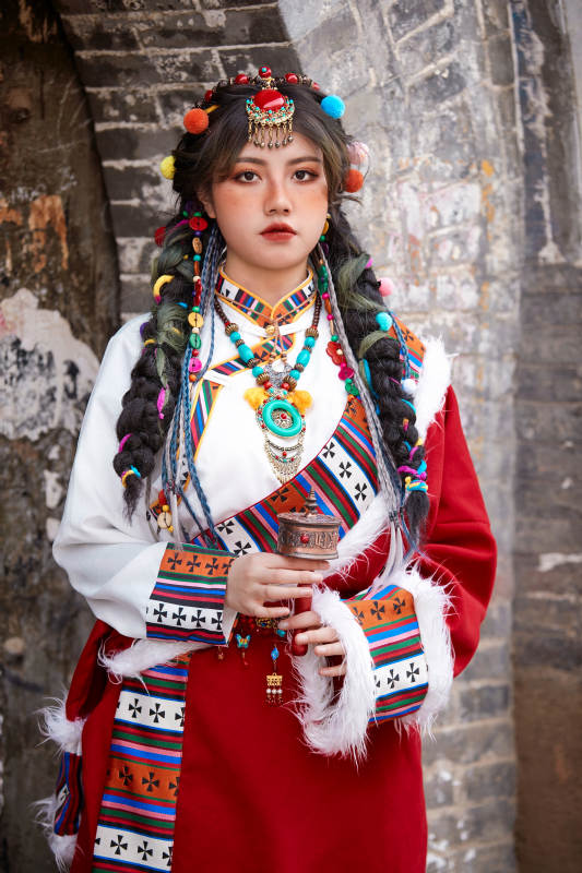 身穿藏族服饰在古城拍照的少女