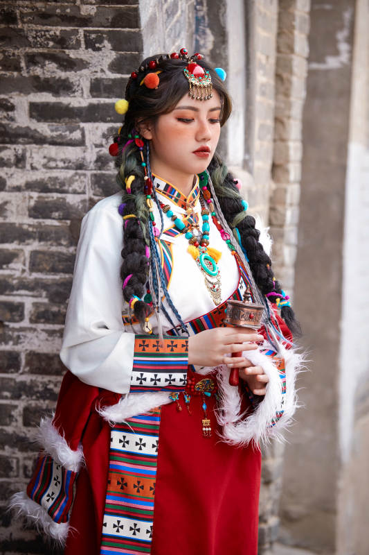 身穿藏族服饰在古城拍照的少女