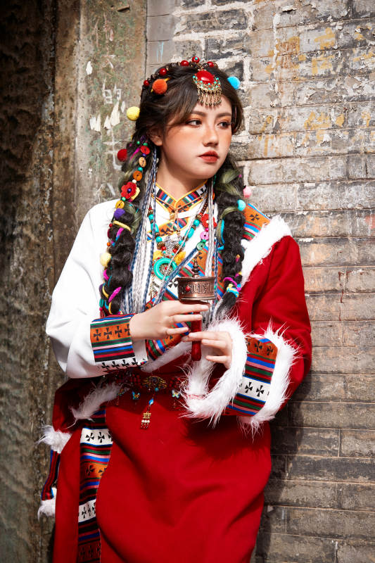 身穿藏族服饰在古城拍照的少女