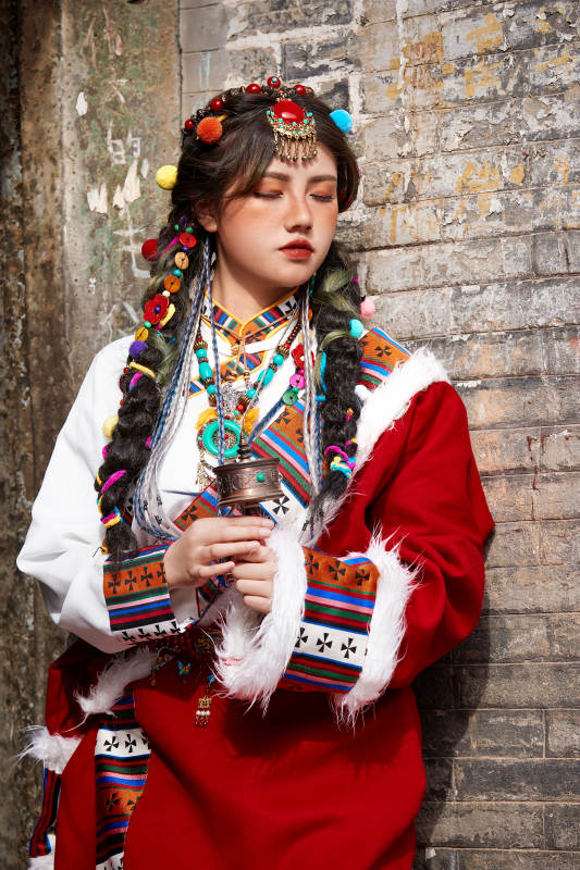 身穿藏族服饰在古城拍照的少女