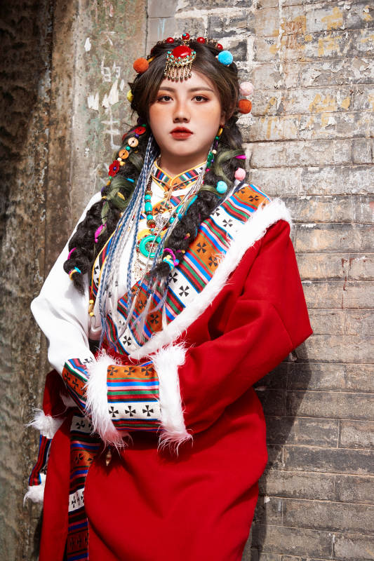 身穿藏族服饰在古城拍照的少女