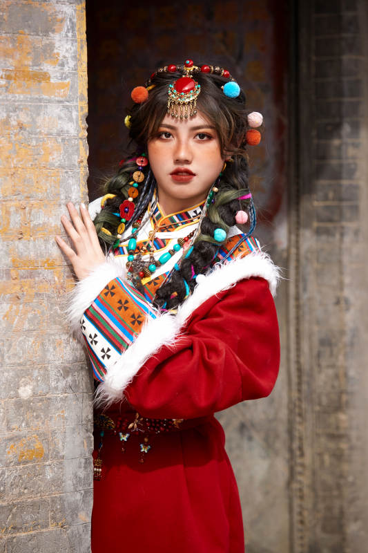 身穿藏族服饰在古城拍照的少女