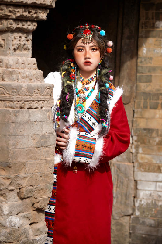 身穿藏族服饰在古城拍照的少女