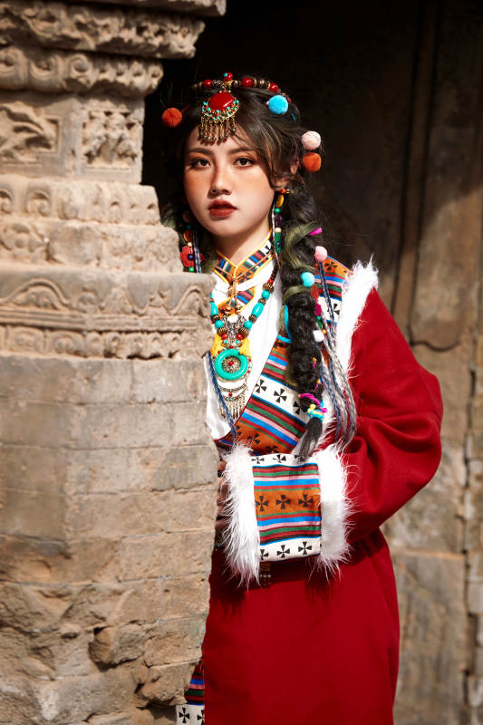 身穿藏族服饰在古城拍照的少女