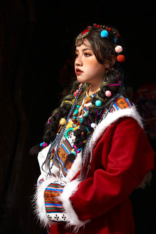 身穿藏族服饰在古城拍照的少女