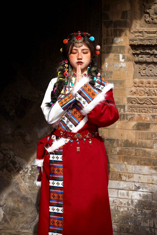 身穿藏族服饰在古城拍照的少女