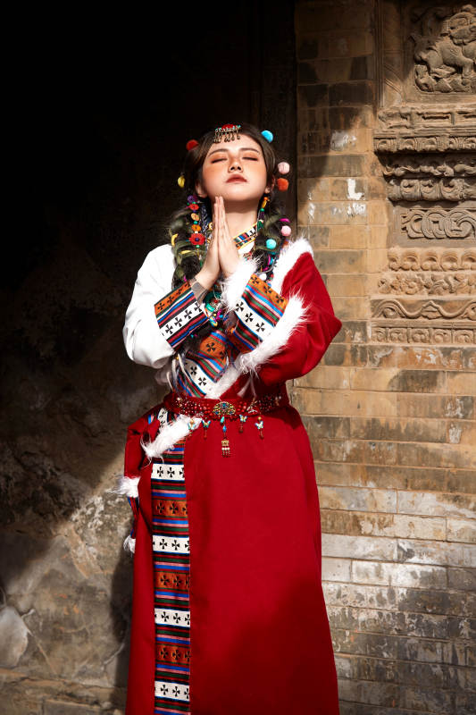 身穿藏族服饰在古城拍照的少女