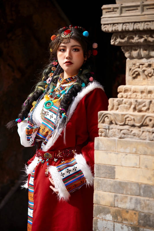 身穿藏族服饰在古城拍照的少女
