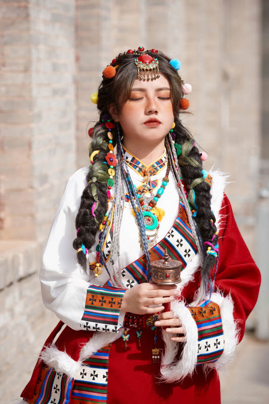 身穿藏族服饰在古城拍照的少女