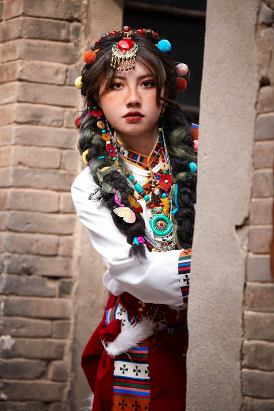 身穿藏族服饰在古城拍照的少女