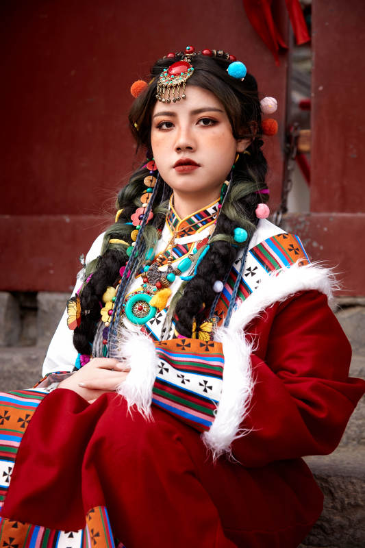 身穿藏族服饰在古城拍照的少女