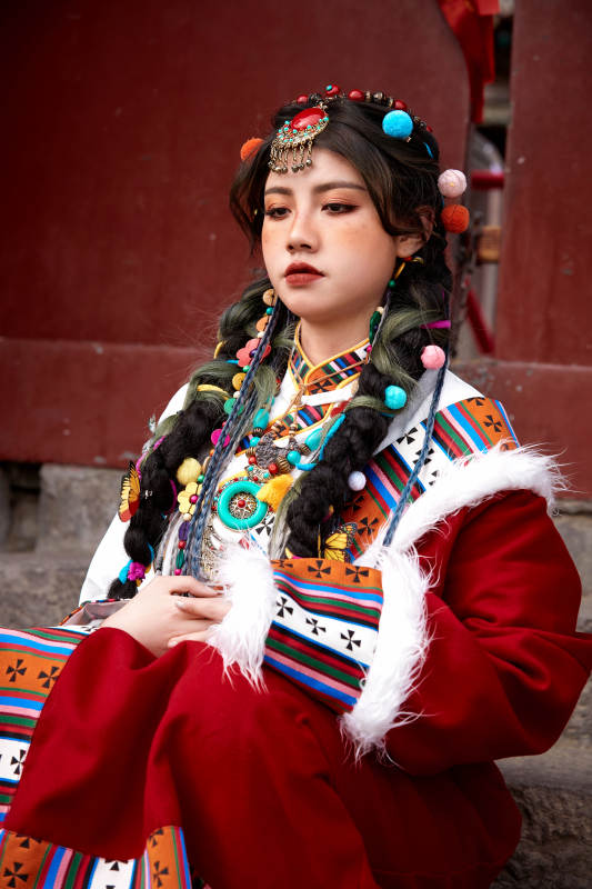 身穿藏族服饰在古城拍照的少女