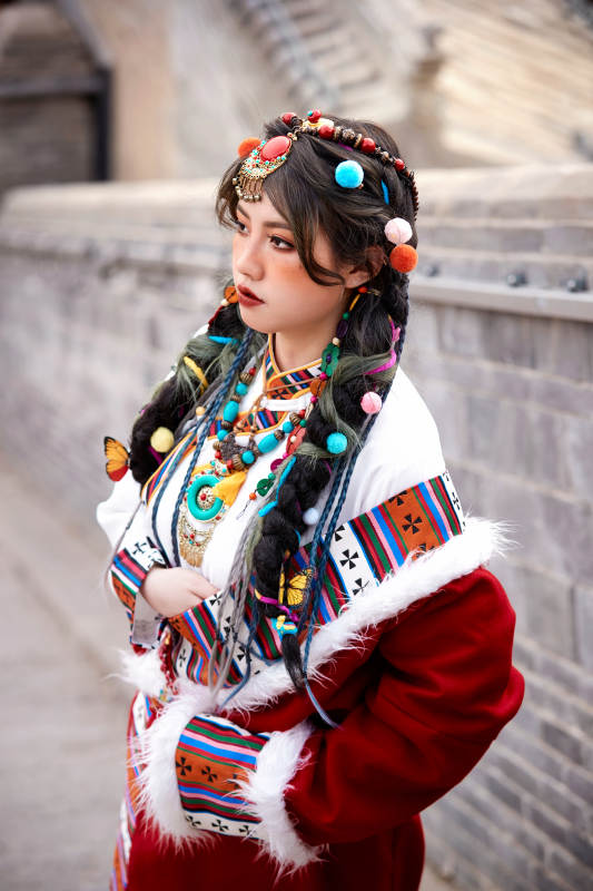身穿藏族服饰在古城拍照的少女