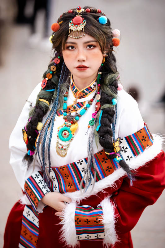 身穿藏族服饰在古城拍照的少女