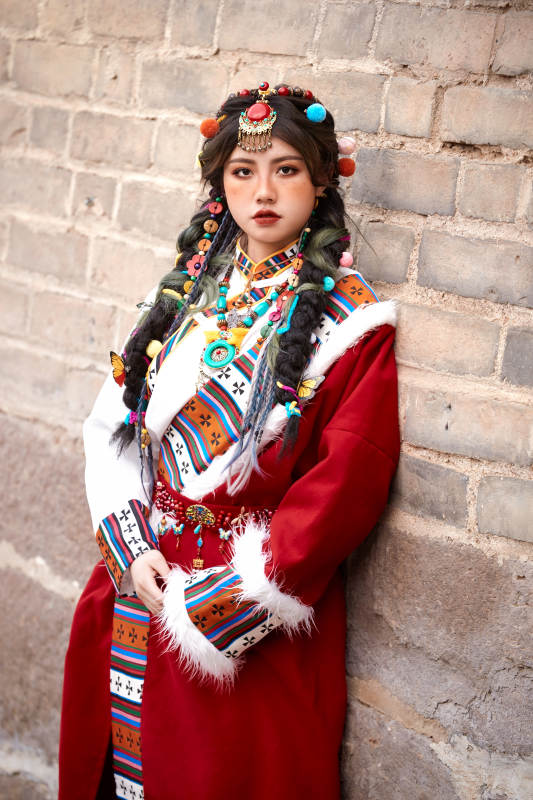 身穿藏族服饰在古城拍照的少女