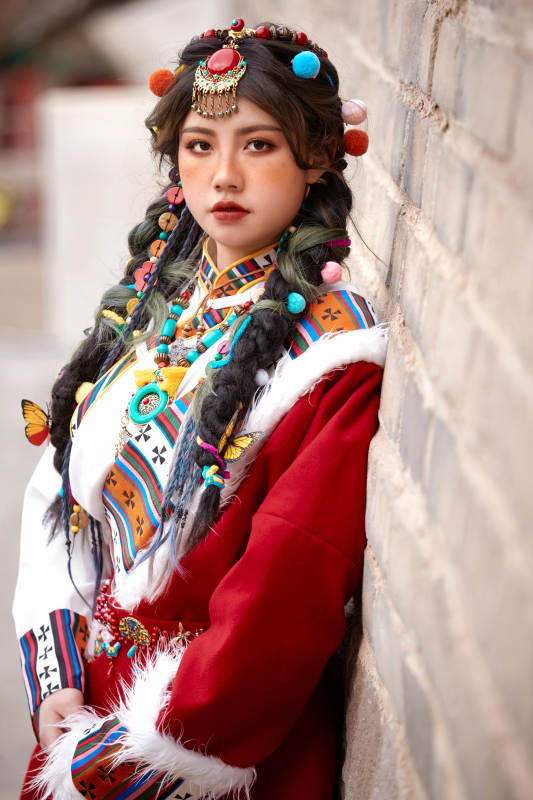 身穿藏族服饰在古城拍照的少女