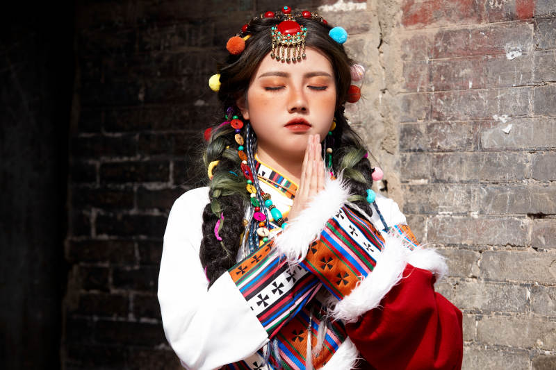 身穿藏族服饰在古城拍照的少女