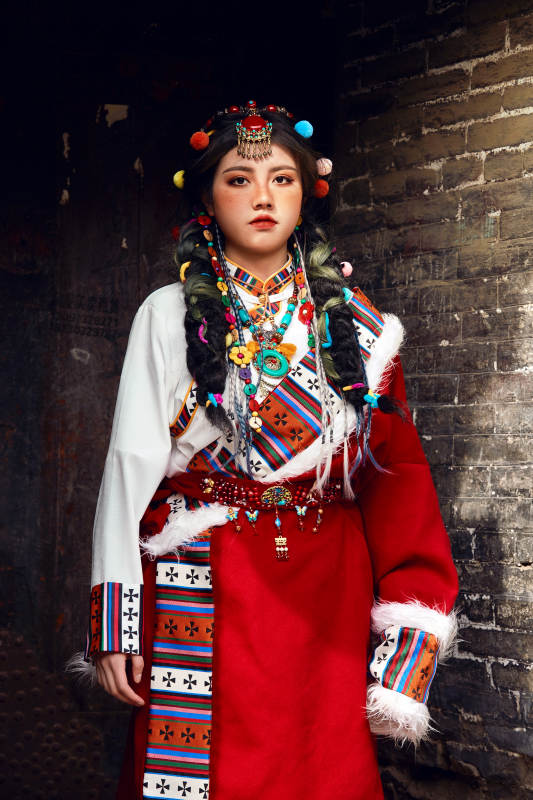 身穿藏族服饰在古城拍照的少女