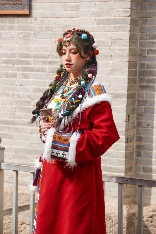 身穿藏族服饰在古城拍照的少女