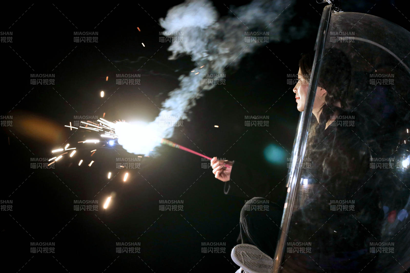 夜晚坐在透明秋千上燃放仙女棒的可爱少女