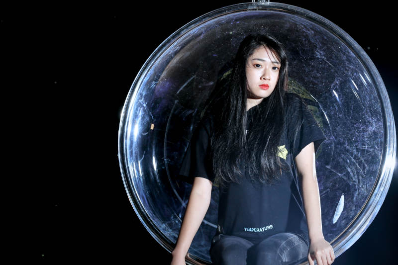 夜晚坐在透明秋千上燃放仙女棒的可爱少女