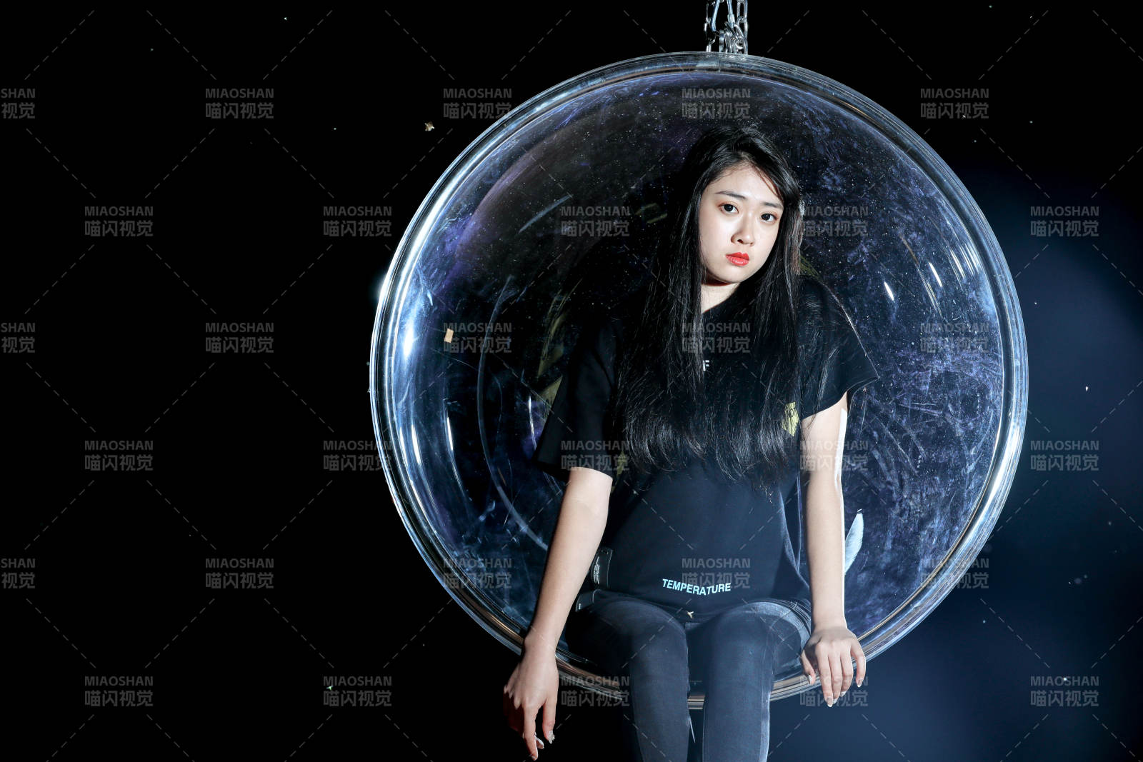 夜晚坐在透明秋千上燃放仙女棒的可爱少女