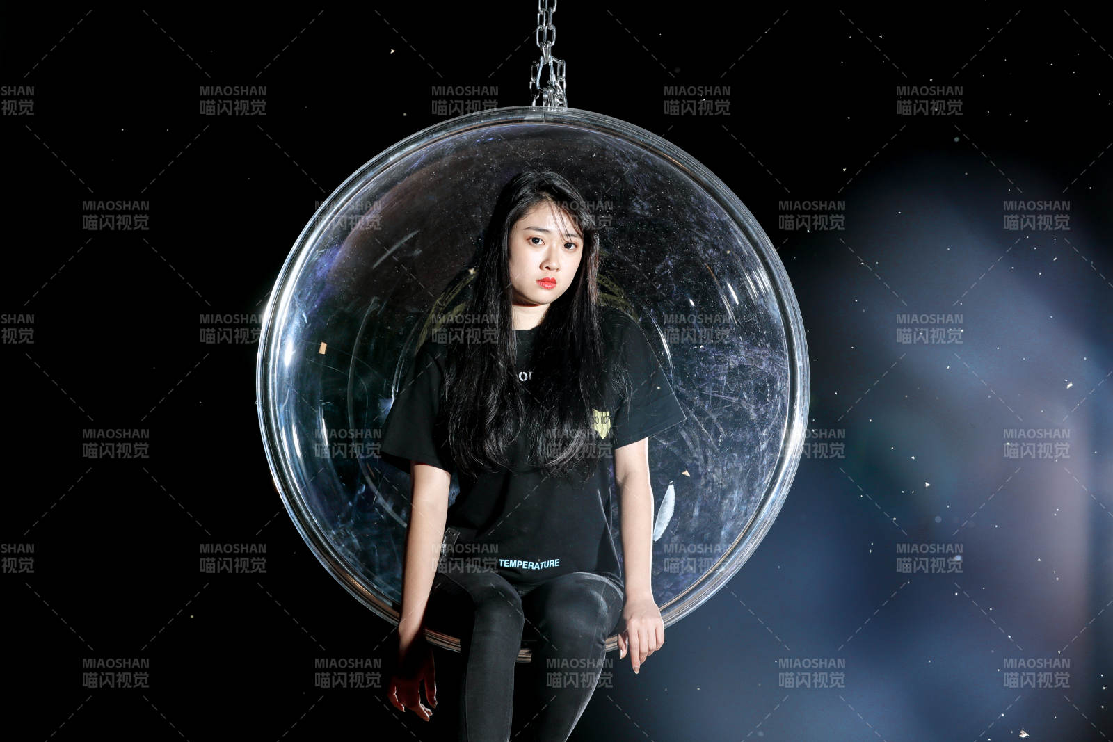 夜晚坐在透明秋千上燃放仙女棒的可爱少女