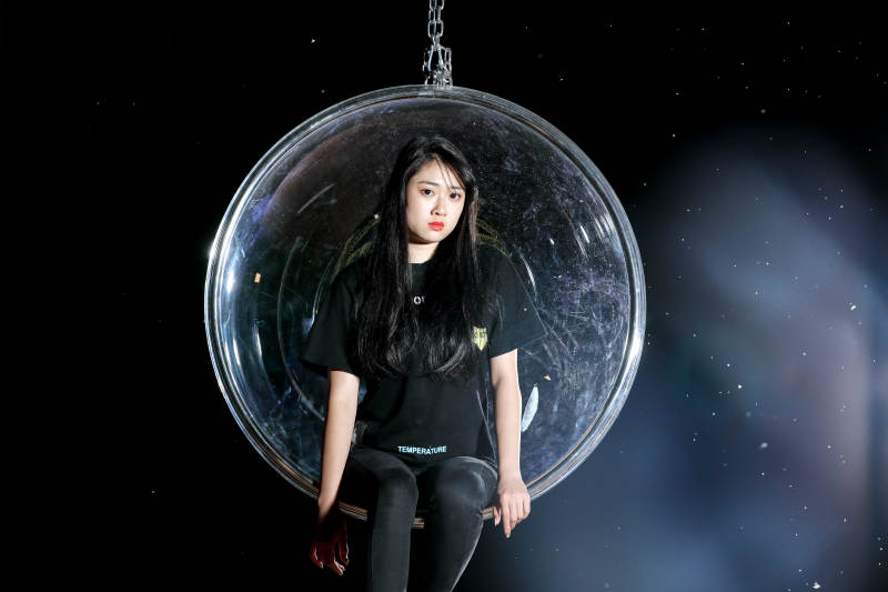 夜晚坐在透明秋千上燃放仙女棒的可爱少女