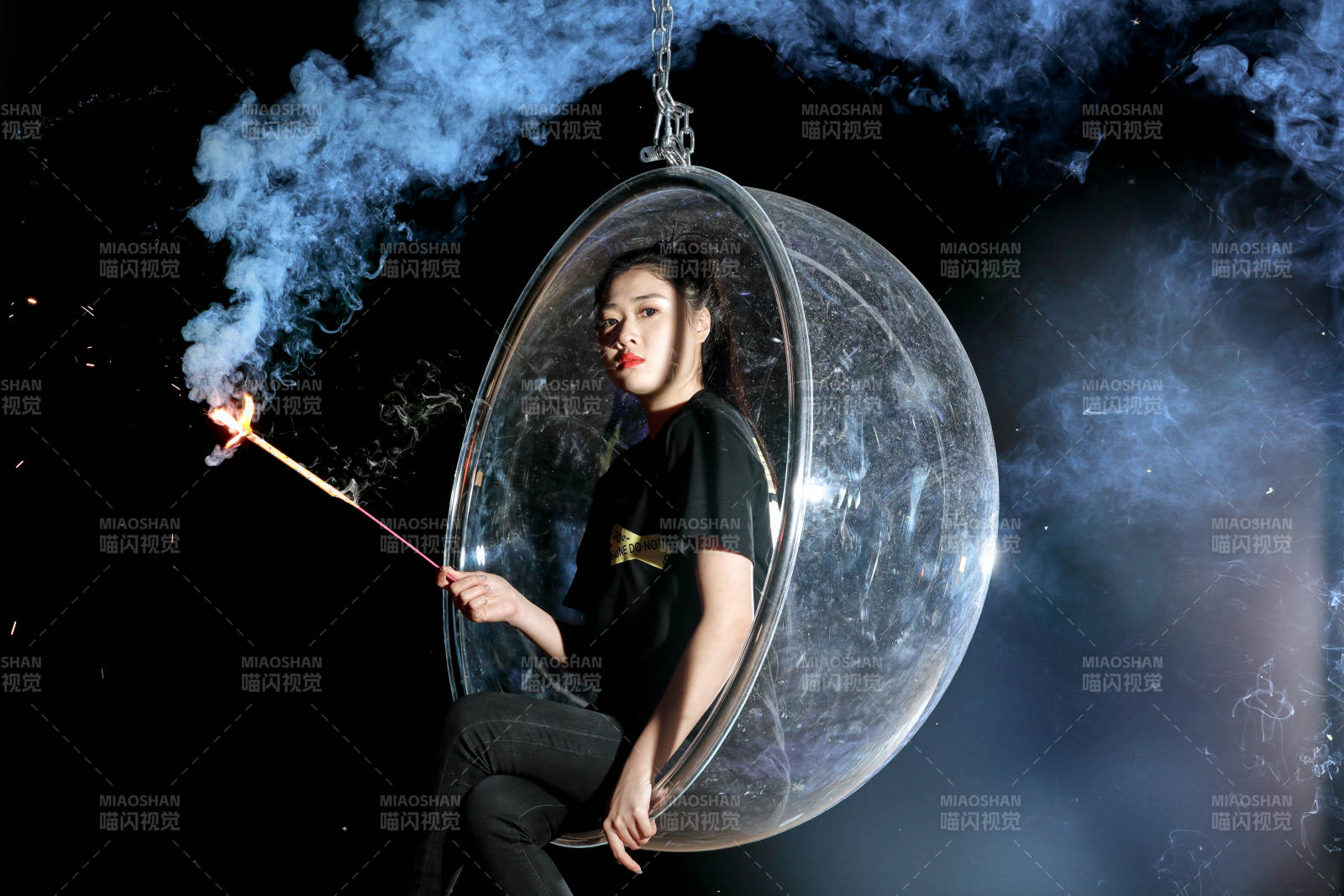 夜晚坐在透明秋千上燃放仙女棒的可爱少女