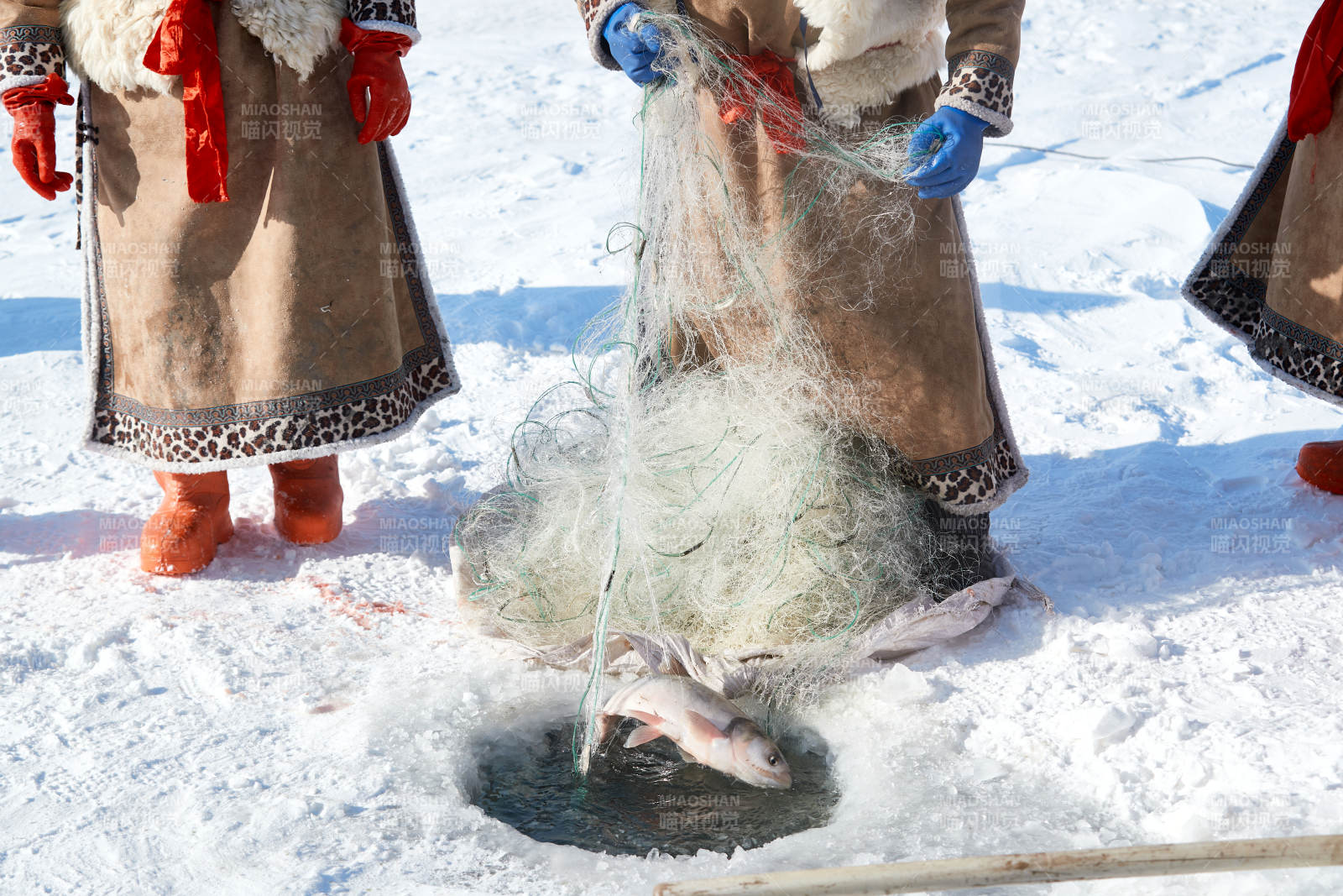寒冷的冬季在冰凍的湖面上鑿冰捕魚