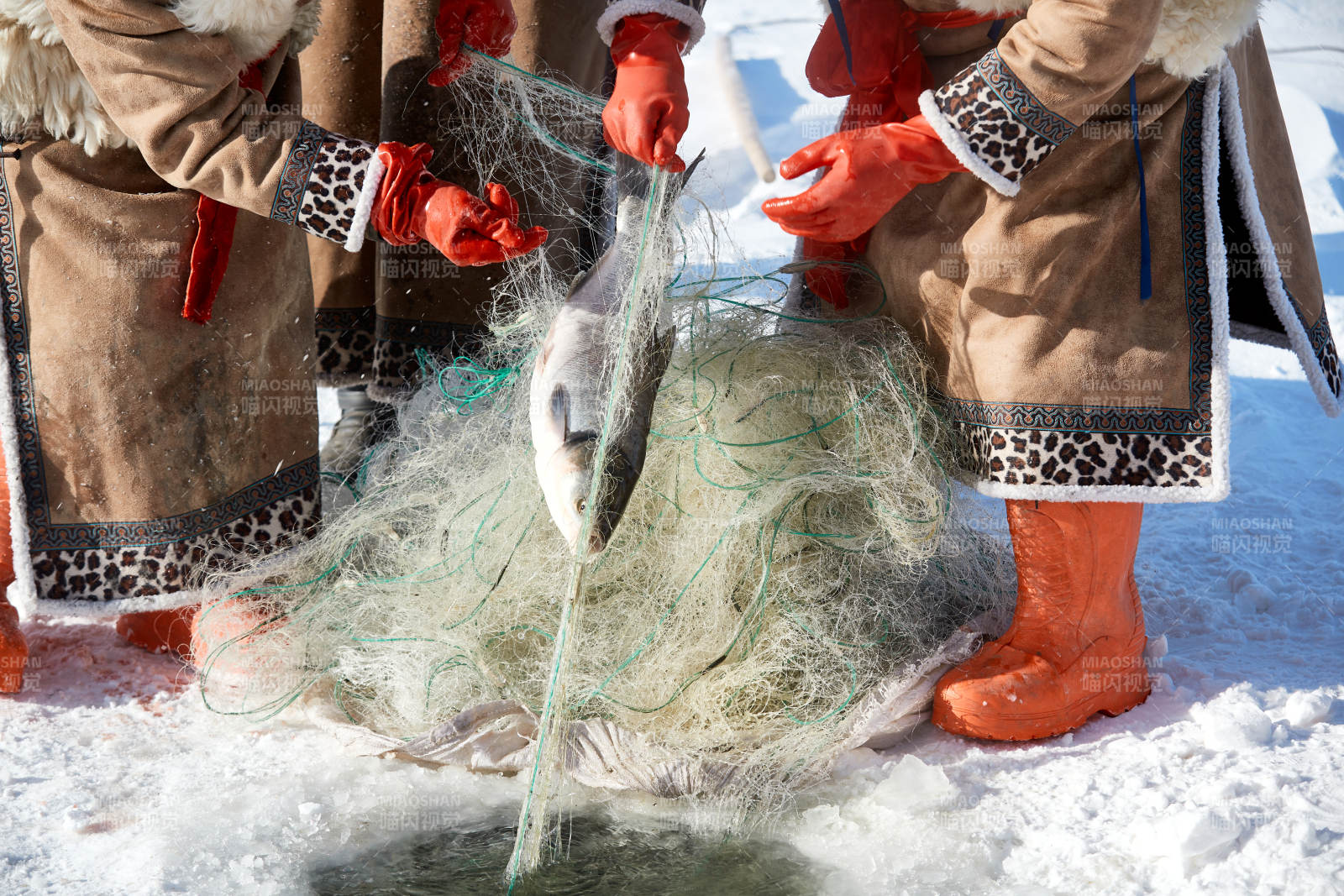 寒冷的冬季在冰凍的湖面上鑿冰捕魚