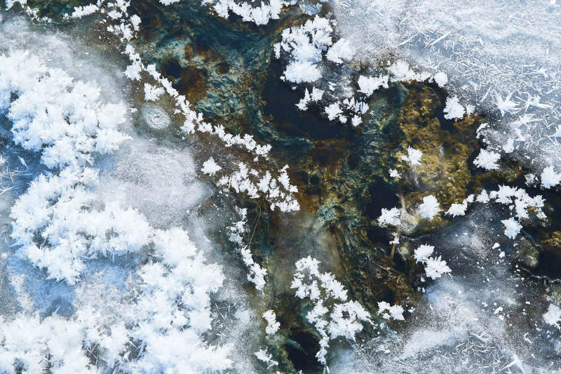 冬天野外溪水冻结冰层上的冰凌花冰松结晶